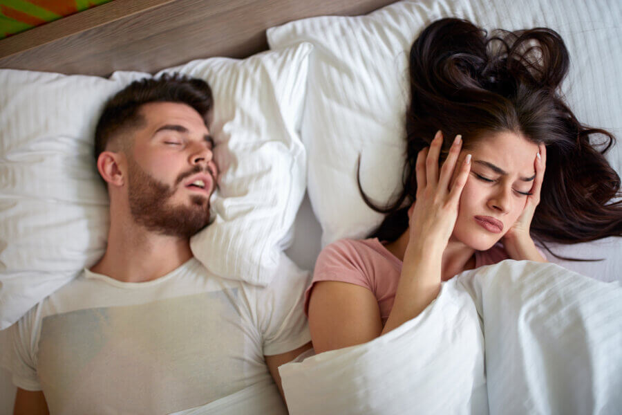 Awake women in bed with snoring husbands